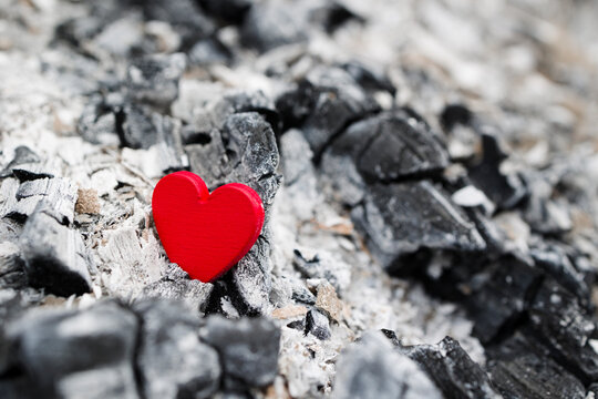 Symbol of broken heart . Wooden red heart in ash