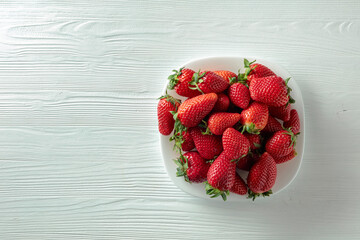 Fresh strawberries on a white wooden table.