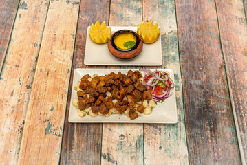 MOTORCYCLE WITH CHICHARRON. With this delicacy, hunger will no longer be a problem. Hot mote and crispy pork rinds and chili sauce on wooden table