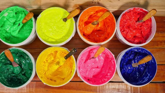 Different colors are organized for t-shirt printing..The color of the ink lays neatly on the wooden floor..colorful of ink background..top view of colorful ink in factory tee shirt.