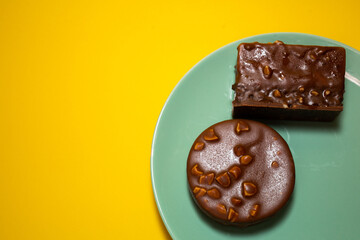 Chocolate tart on a green plate. Yellow background, top view