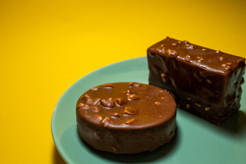Chocolate tart on a green plate. Yellow background, top view