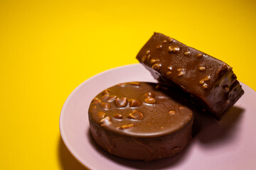 Chocolate tart on a pink plate. Yellow background, top view