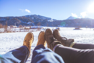 Loving couple is enjoying winter time, outdoors. Close up of winter boots. - 497953469