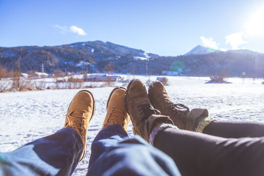 Loving couple is enjoying winter time, outdoors. Close up of winter boots.