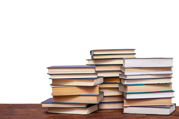 Three stacks of books on a wooden table, isolated on a white background.