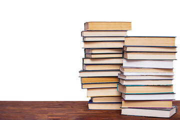 Two stacks of books on a wooden table, isolated on a white background.