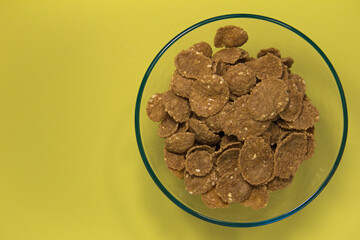 Flakes on a plate. On a yellow background. Place for text.