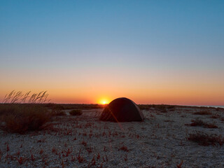 Fototapeta na wymiar Camping on a beach at sunrise on Tendra Spit, Kherson Oblast, Ukraine.