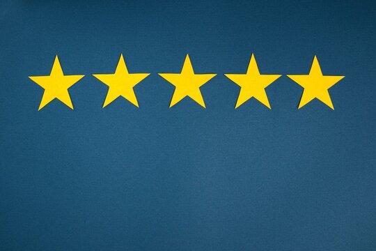 Rating in the form of yellow stars on a blue background. The concept of service quality assessment.
