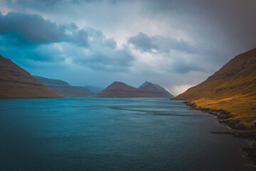 Faroe Islands, Kalsoy island, Husar village in sunset light durig twilight with pink sky and cliffs. November 2021