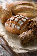 Bakery products on the kitchen rustic table. Various types of fresh fragrant crispy freshly baked bread on a wooden background. Appetizing bun and baguettes close-up. Healthy food and bakery concept.