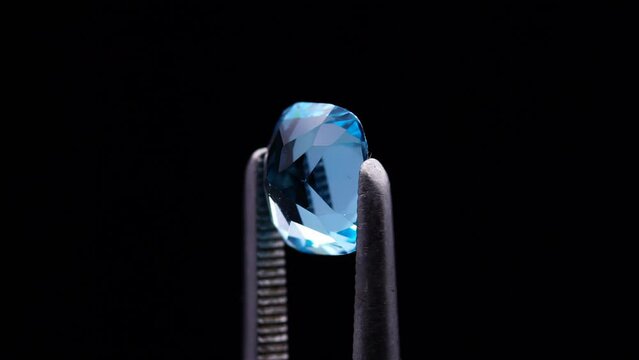 natural blue topaz cushion cut in the turning tweezers