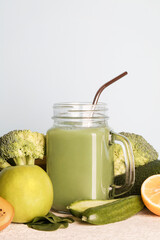 fresh green smoothie in glass bottle with vegetables on blue background.vegan food, self care and healthy lifestyle.Healthy detox diet