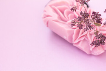 Pink herbal soap carved in beautiful flower, dry flowers on pink background, copy space, mock up
