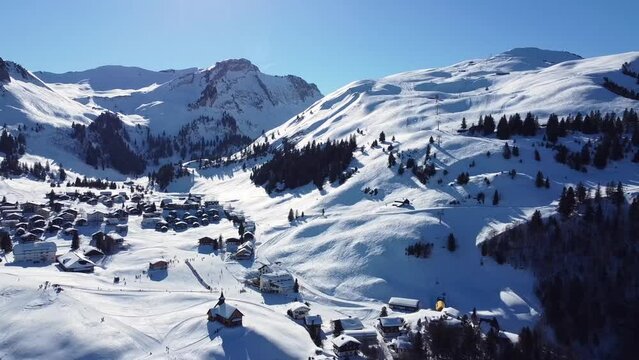 Ski area Stoos in the swiss mountains in winter covered with snow and forest on the mountains, and blue sky, Swiss Alps. Aerial video in Stoos, Schwyz, Switzerland.