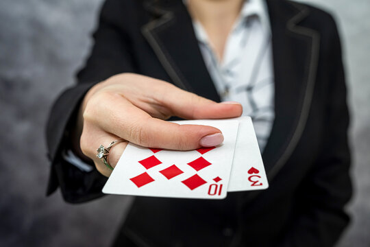 woman in suit shows a winning combination on cards