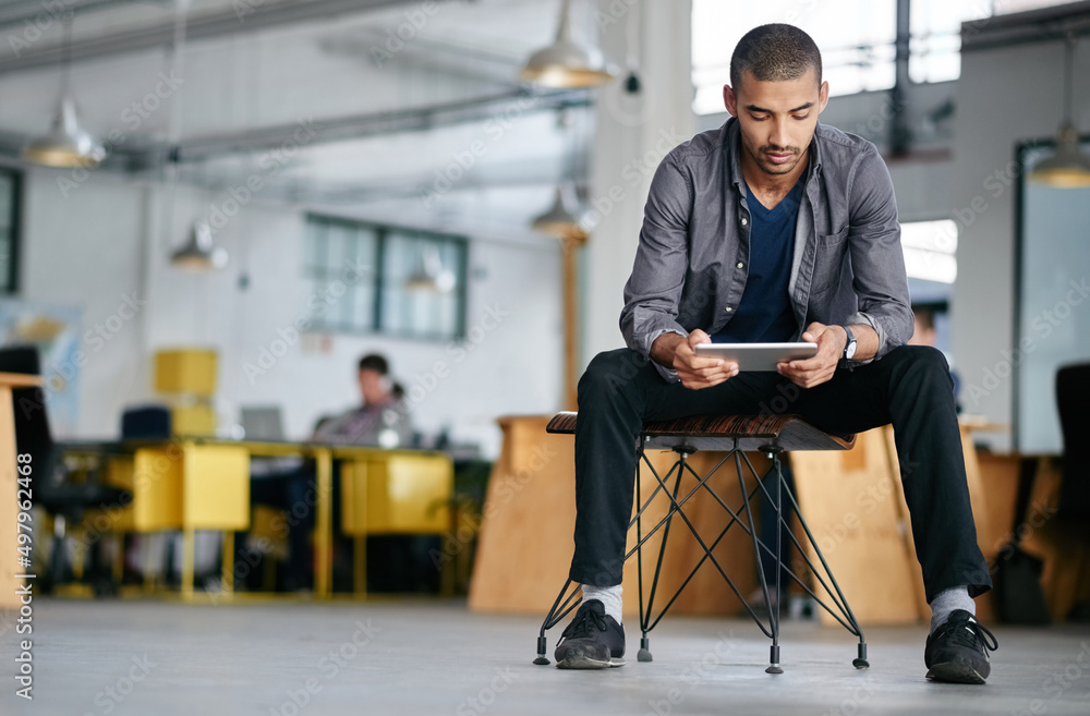 Aufkleber hes a tech savvy young designer. shot of a young man using a digital tablet while sitting in a moder