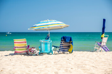 Beach chairs and umbrella, located on a beach in the Mediterranean, on a  bright sunny, summer's day