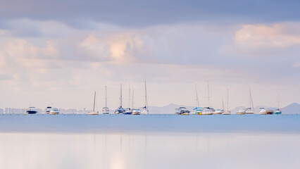 Sailing boats, anchored offshore, in the Mediterranean, on a calm, summers morning.  The boats are...