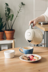 breakfast with coffee in the kitchen. wooden table in the kitchen. Scandinavian style. White wooden background. Bright kitchen interior. table setting for dinner. Coffee time.