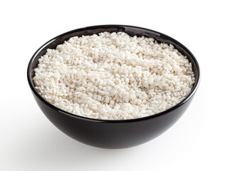 Uncooked arborio rice in black ceramic bowl isolated on white background with clipping path