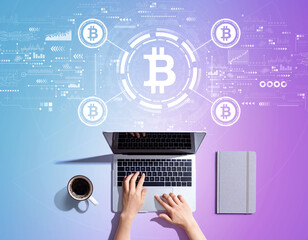 Bitcoin theme with person using a laptop computer