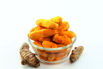 fresh peeled and unpeeled turmeric root in bowl isolated on white background