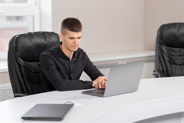 Businessman sitting at work looking at laptop. Office work concept