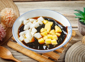 Stuffed fairy grass jelly in a dish side view on wooden table taiwan food