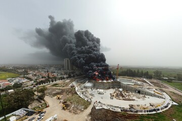 Acre, Israel - April 8 2022: Bahai construction site caught fire and huge smoke pillar covering residential neighborhood 