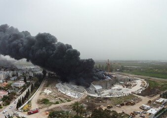 Acre, Israel - April 8 2022: Bahai construction site caught fire and huge smoke pillar covering residential neighborhood 