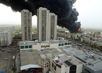 Acre, Israel - April 8 2022: Bahai construction site caught fire and huge smoke pillar covering residential neighborhood 