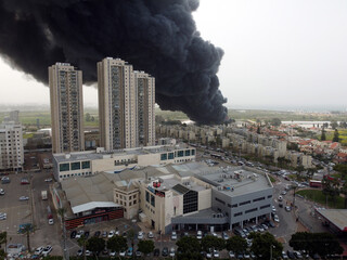Acre, Israel - April 8 2022: Bahai construction site caught fire and huge smoke pillar covering residential neighborhood 
