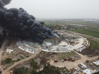 Acre, Israel - April 8 2022: Bahai construction site caught fire and huge smoke pillar covering residential neighborhood 