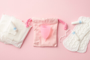 Top view photo of pink period pad bag menstrual cup sanitary napkins and tampons on isolated pastel pink background. Uterus and ovaries concept - obrazy, fototapety, plakaty