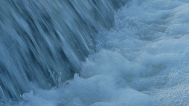 Forest waterfall in winter. Huge flow of water blustering waterfall. High quality FullHD footage