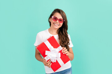 boxing day. smiling kid with present box. teen girl giving birthday gift. child in sunglasses