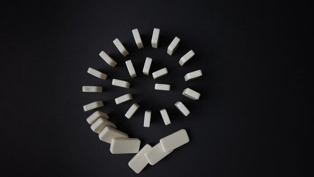 Falling dominoes. Chain reaction, built figure of dominoes falling in slow motion. View from above.