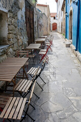Fototapeta na wymiar Empty narrow pedestrian street with cafe tables and chairs in Limassol Old town, Cyprus