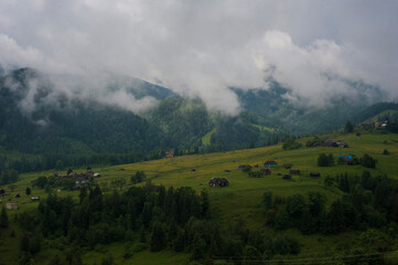 Fototapeta na wymiar Fog and rain in the Carpathian mountains. Mountain village Dzembronya in the Carpathian mountains, Ukraine. Panoramic photo of mystical mountain landscape.