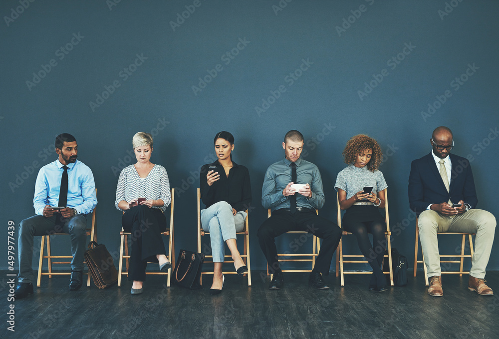 Aufkleber It could be anyone of us. Shot of a group of well-dressed business people seated in line while waiting to be interview.