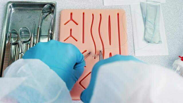 Surgeon trains to apply stitches on a special silicon pad, medical attributes