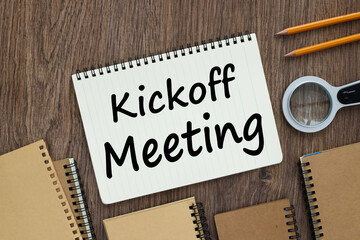 Kick-Off Meeting. open notepad with text near many notepads and magnifier