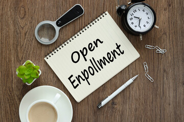 open enrollment. notepad on a wooden background with text