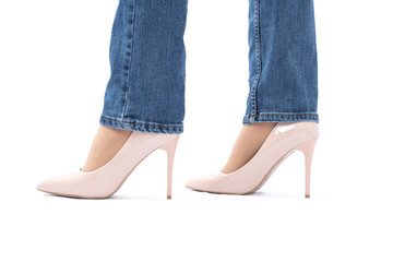 Slender female legs in high-heeled patent leather shoes. Blue jeans. Fashion and Style. side view