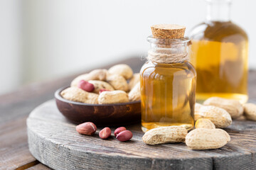 Concept of organic vegetable oils for cooking and cosmetology. Peanut nuts to illustrate...