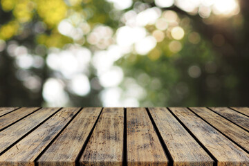 Empty Rustic Plank Wood Table top with Blured Tree Bokeh Background