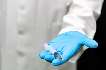 The medical syringe in the doctor's hand is a close-up. A doctor in blue gloves holds a syringe with a coronavirus vaccination. Compulsory vaccination of the population against covid19