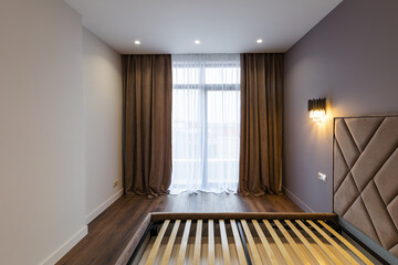 Interior design of a spacious bright bedroom in the Scandinavian style. A combination of white gray and beige. Modern stylish bedroom design.